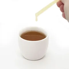 Honey stick dripping into tea